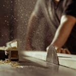 A man cuts wood on a circular saw in a joinery